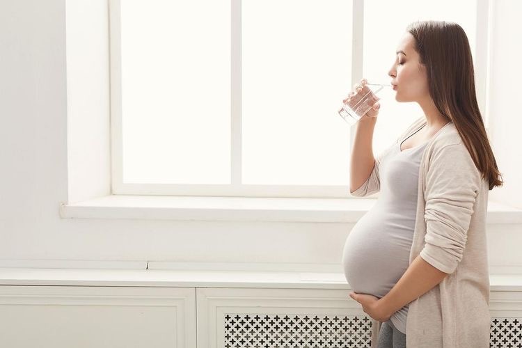 Беременная женщина пьет воду