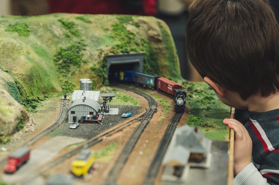 мальчик играет с железной дорогой