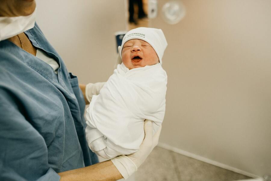 новорожденный на руках у врача