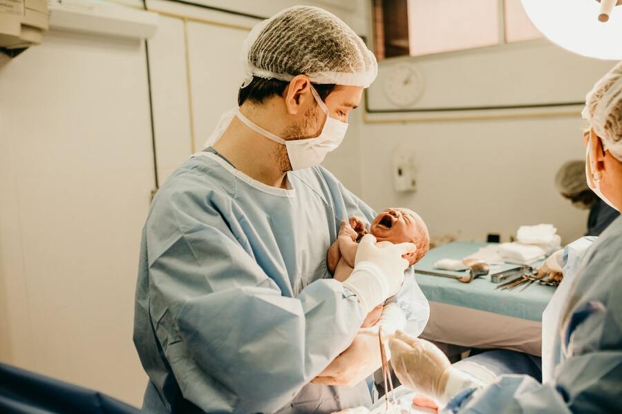 новорожденный на руках у врача