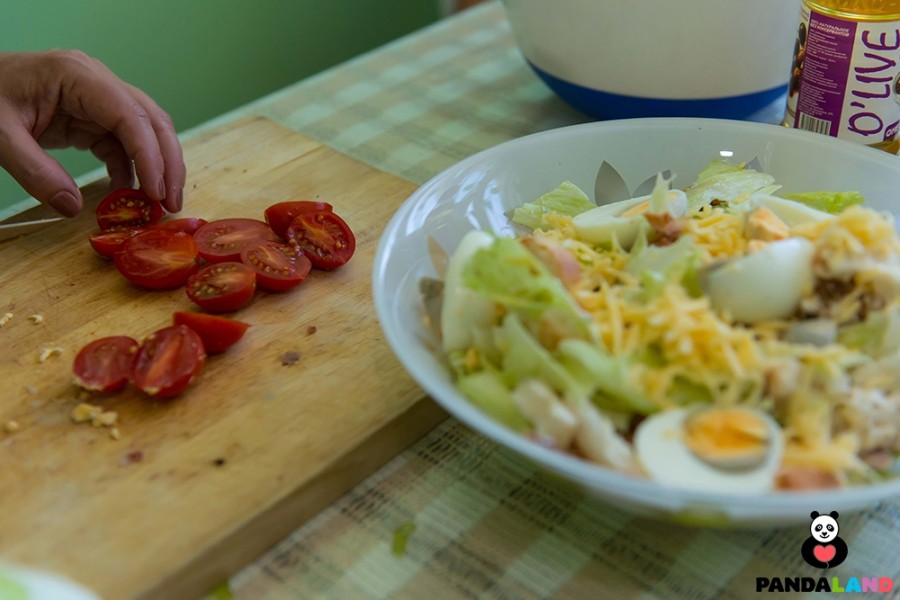 Салат Цезарь украшен порезанными варенными яйцами и помидорками «Чери»