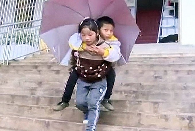 Детская самоотверженность: 9-летняя китаянка каждый день носит брата в школу на своих плечах (видео)